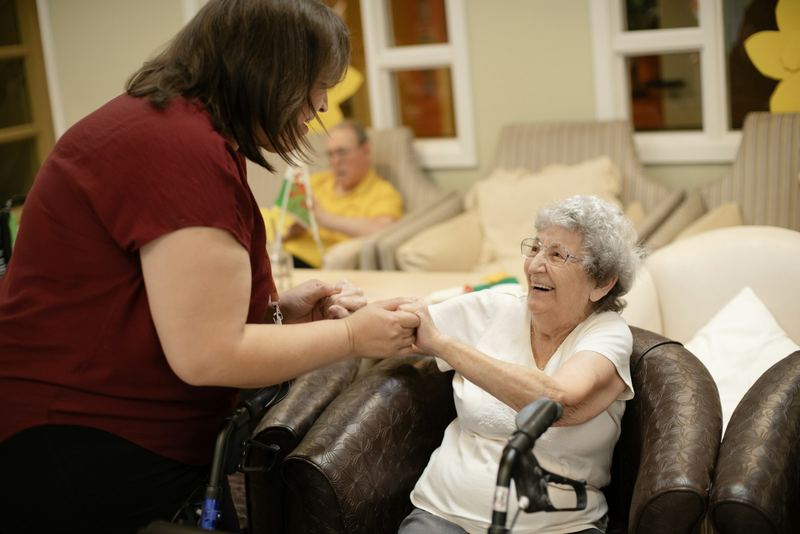 A Golden Touch caregiver holding a senior's hands at home