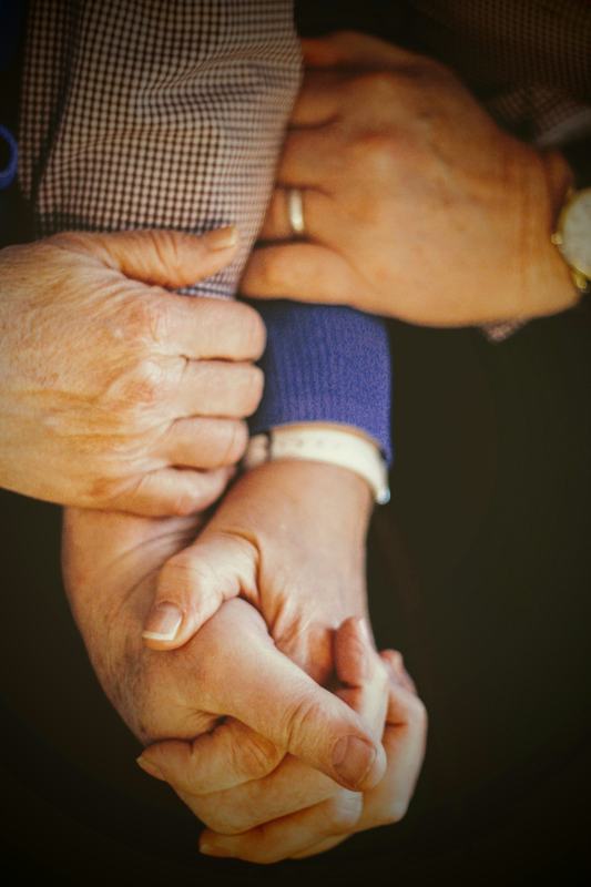 Golden Touch caregiver holding hands and providing specialized in-home care support in Greater Hartford, CT