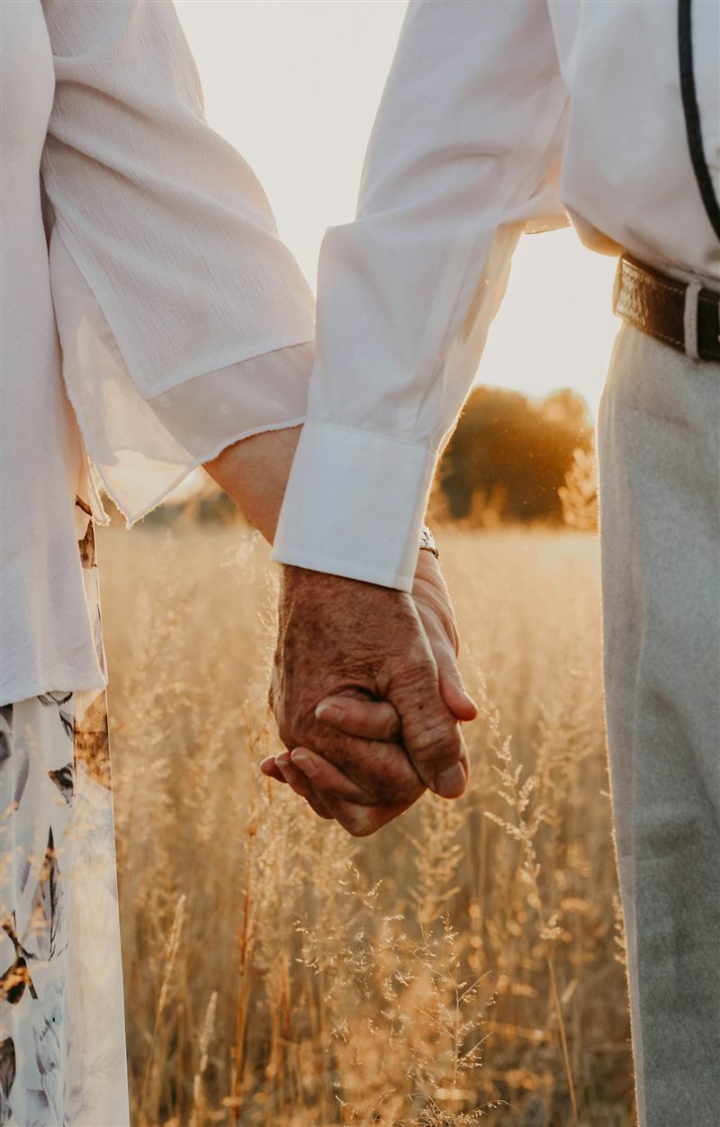 A younger hand holding an elderly hand
