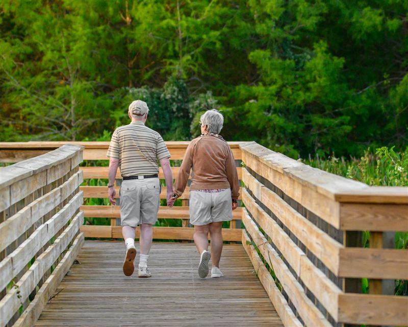 Senior couple walking hand in hand on a boardwalk
